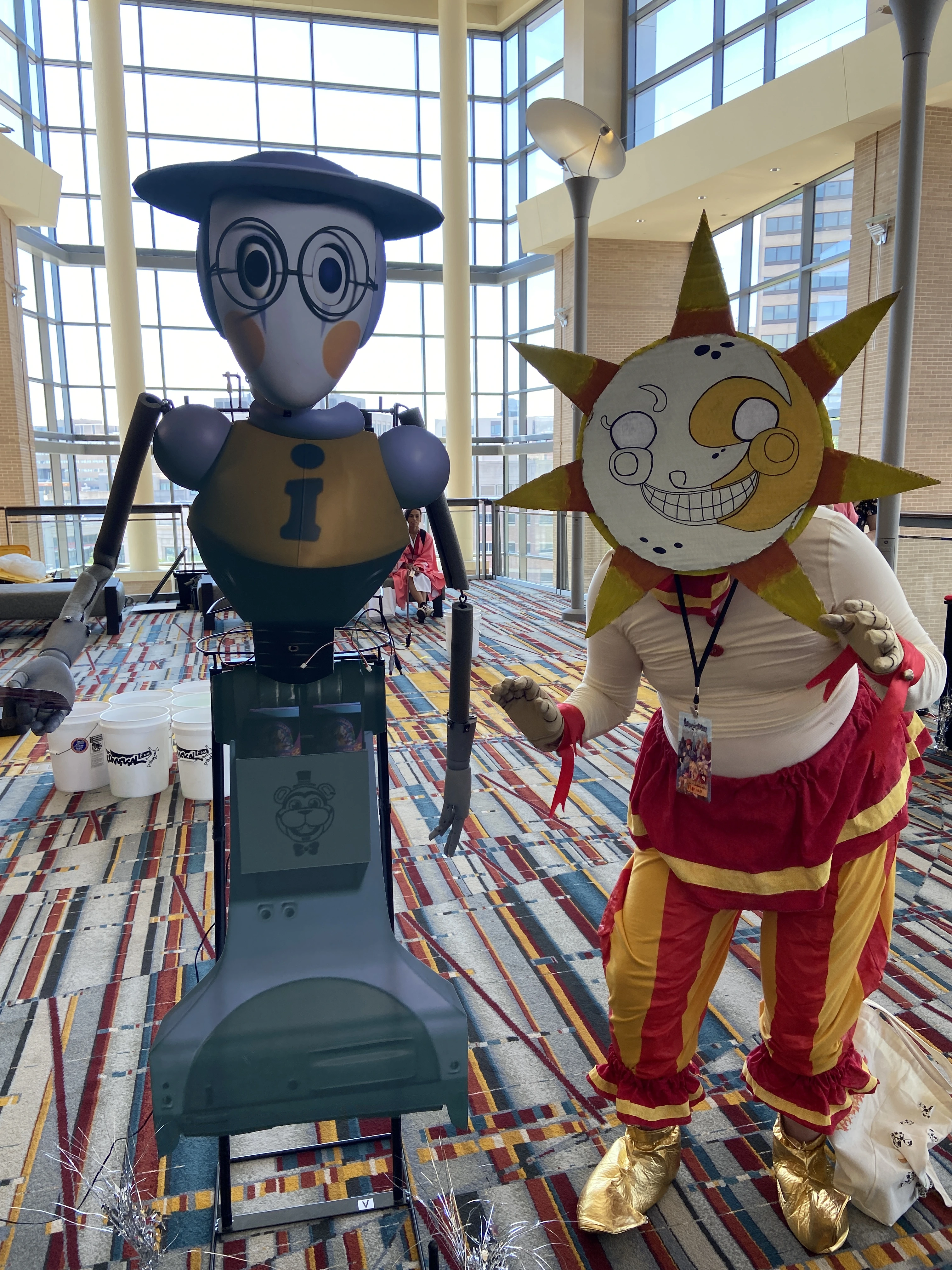 Me in my sun costume next to a cardboard cutout of a bot from Security Breach